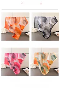 Detail of silk-like square scarves with abstract art prints in four stylish colors