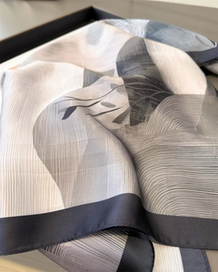 Macro detail of gradient silk scarf with abstract textures and elegant draping