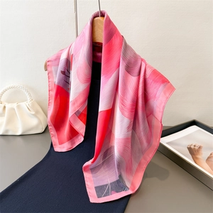 Elegant gradient print silk scarf with pink and purple fluid patterns on a wooden hanger