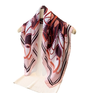 Elegant silk-like scarf with equestrian chain print in pink and burgundy hanging on a top