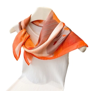 Elegant gradient orange silk-feel square scarf with pleated texture on a mannequin