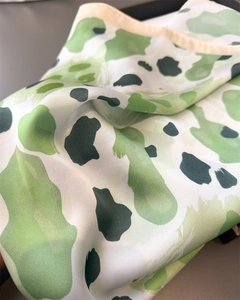 Détail d'un foulard en satin de soie avec imprimé aquarelle vert, plis doux et grand éclat