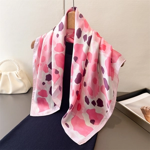 Foulard en satin rose à imprimé léopard sur cintre en bois avec un sac à anse perle