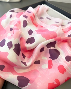 Gros plan d'un foulard en satin aux motifs léopard abstraits roses et violets