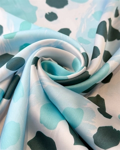 Macro d'un foulard en satin de soie à motif léopard montrant la texture lisse et brillante