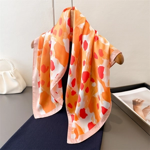 Foulard carré élégant en soie avec imprimé abstrait sur un cintre en bois