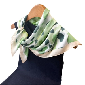 Élégant foulard en soie à imprimé léopard vert et gris sur un cintre en bois naturel