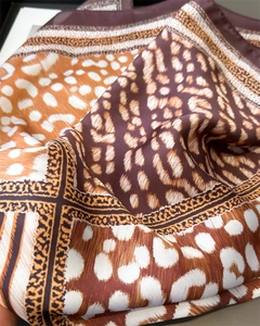 Vue détaillée de la texture soyeuse du foulard avec motifs léopard et tigre