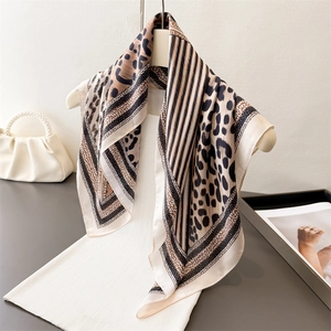 Élégant foulard en soie à imprimé léopard et rayures sur un cintre blanc pour femme