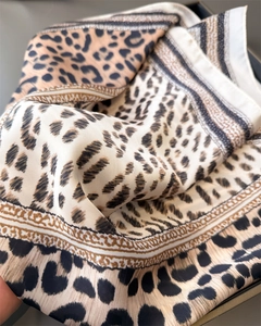 Vue détaillée du foulard en soie léopard avec texture lisse et motifs de chaînes
