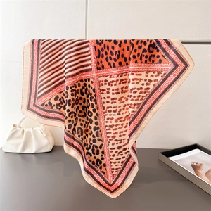 Gros plan d'un foulard en satin imprimé léopard drapé avec élégance sur un support