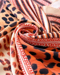 Détail du foulard en soie léopard montrant la texture satinée et motifs géométriques