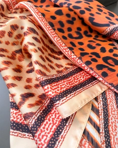 Vue macro d'un foulard léopard effet soie avec coutures fines et éclat satiné