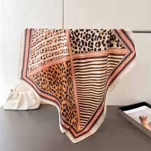 Foulard élégant en soie léopard avec sac à main en perles dans un décor minimaliste chic