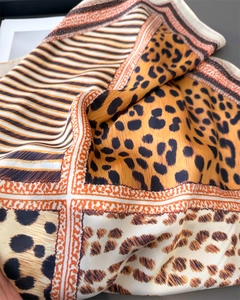 Détail d'un foulard en soie léopard avec motifs géométriques et reflets satinés doux
