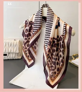 Detail of silk-like leopard print scarf featuring striped patterns and purple borders