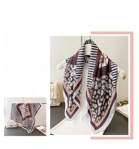 Macro detail of silk-like leopard print scarf featuring rich brown animal patterns