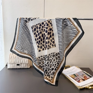 Close-up of leopard and stripe print satin scarf with smooth silk-like texture