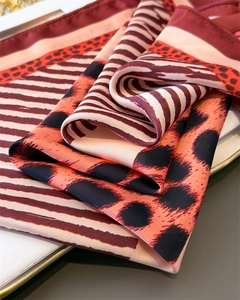 Detailed macro view of leopard print silk scarf texture on a white ceramic plate