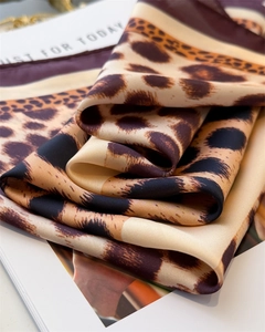 Detail of leopard print silk scarf with purple border showing smooth fabric texture