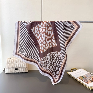 Detail of elegant leopard print satin square scarf with chic monochrome stripes on display