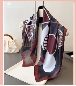 Detail of silk-like scarf featuring geometric pop art patterns and burgundy edges