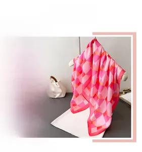 Détail macro du foulard en soie avec motif à carreaux géométriques rose et orange