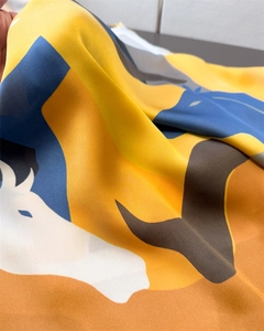 Detailed close-up of luxurious satin scarf featuring abstract horse prints and vibrant colors