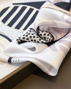 Detailed view of geometric silk scarf with black white grey polka dots and stripes