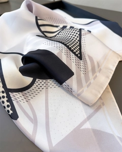 Macro view of geometric silk-like scarf with black and white abstract print texture