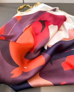 Close-up of silky geometric pattern scarf with elegant draping and glossy finish