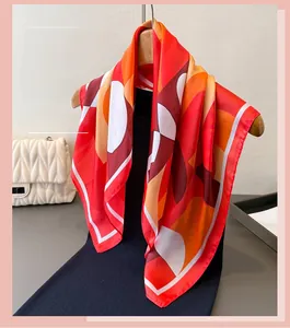 Détail d'un foulard en soie à motifs géométriques colorés drapé sur un cintre