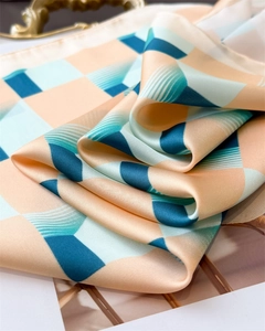 Gros plan d'un foulard en soie au motif géométrique et texture soyeuse rose et bleu