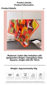 Détail d'un foulard en soie à motif géométrique montrant le satin et les blocs de couleur