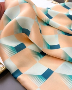 Détail du foulard en soie au motif géométrique 3D avec une texture satinée de qualité