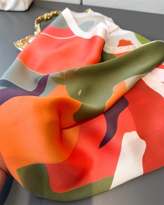 Macro detail of high-quality imitation silk scarf with vibrant abstract geometric patterns