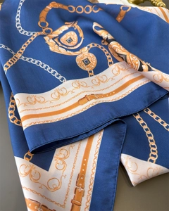 Macro detail of silk-like scarf with gold chain print and smooth satin texture