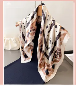Détail d'un foulard en soie à imprimé zèbre et géométrique sur un cintre en bois