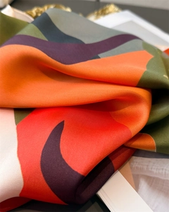 Macro detail of geometric patterned silk scarf showing luxurious texture and drape