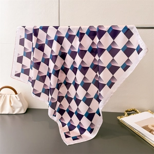 Détail d'un élégant foulard carré effet soie avec motifs géométriques rose et violet