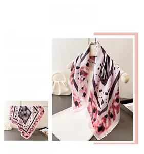 Détail d'un foulard en soie à imprimé zèbre rose et noir avec motifs géométriques chic