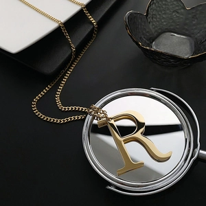 Minimalist gold letter R pendant necklace on a Cuban chain for a stylish hip hop aesthetic