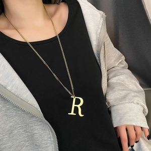 Long gold necklace featuring a polished letter R pendant on a classic flat chain