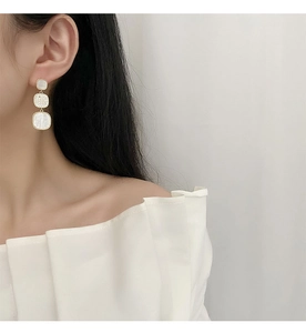 Detail of three-tier square drop earrings with mother-of-pearl and micro-set crystals