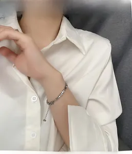Detailed close-up of a silver cube bead bracelet with adjustable chain on a model's wrist