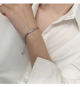 Detail of square bead titanium steel bracelet with adjustable extension on a silk sleeve