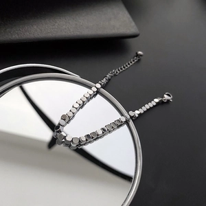 Minimalist silver titanium steel cube bead bracelet with lobster clasp on mirror