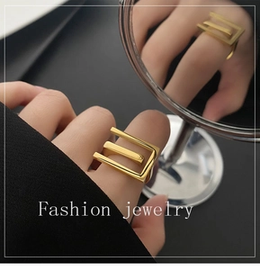 Detail of 18k gold plated stainless steel geometric ring shown on finger with mirror reflection