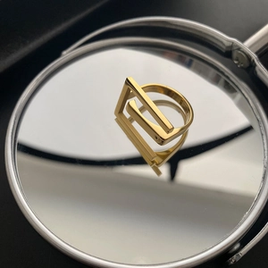 Detailed close-up of a gold 18k plated titanium steel ring with geometric hollow design