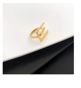 Close-up of a minimalist 18k gold plated stainless steel ring with a geometric E-shape design
